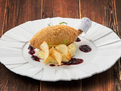 Chicken Kiev with mashed potatoes and black currant sauce