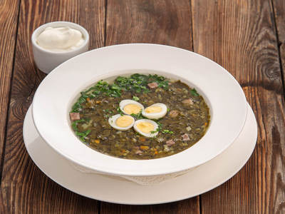 Green vegetables soup with sorrel, boiled tongue and quail eggs